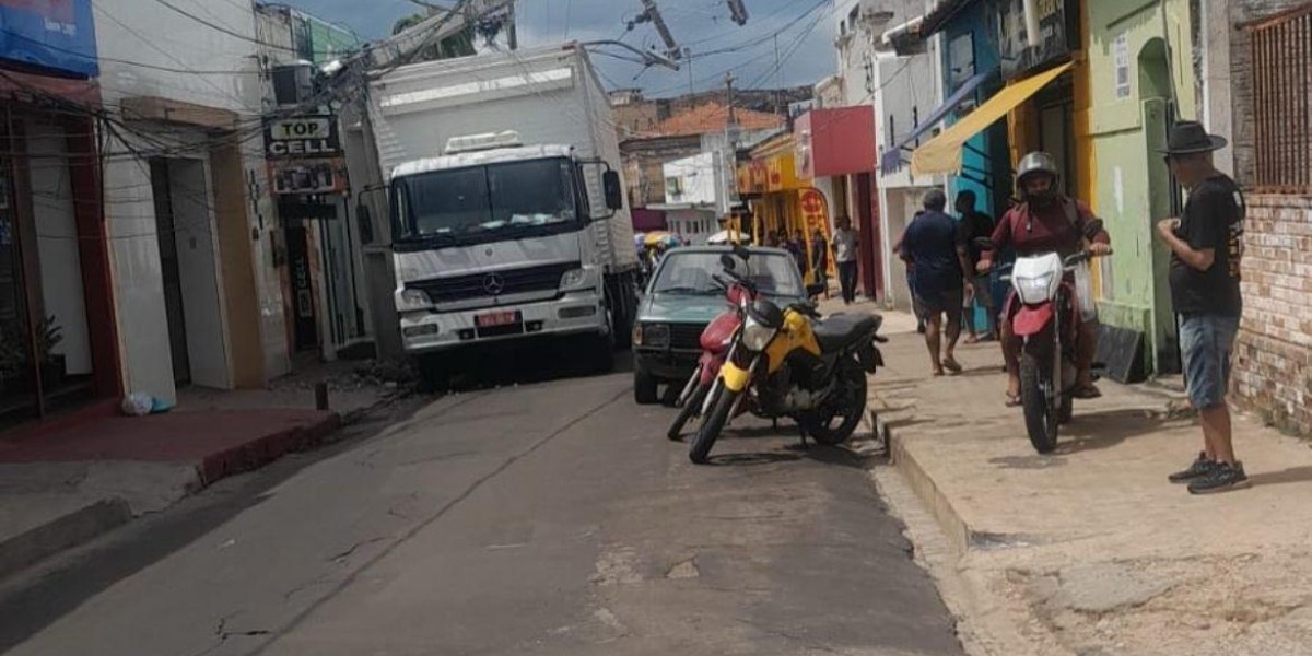 Caminhão derruba poste  de energia elétrica e deixa  motorista preso